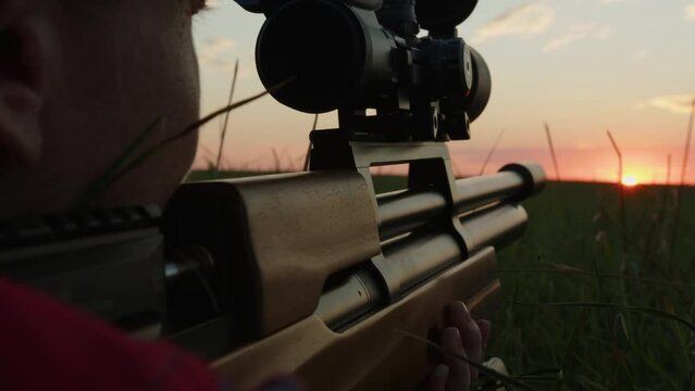 Woman hunter aiming from gun close-up. Hunting season. 