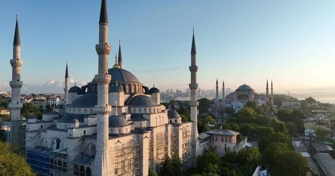 Istanbul, Turkey. Sultanahmet with the Blue Mosque and the Hagia Sophia with a Golden Horn on the background at sunrise. Cinematic Aerial view.