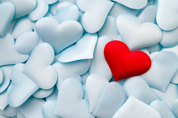 One single red textile heart on multiple pastel blue hearts with copy space concept for bond...