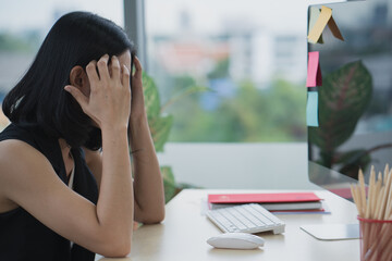 Asian business woman headache stressed because of work mistake problems about profit losses to be...