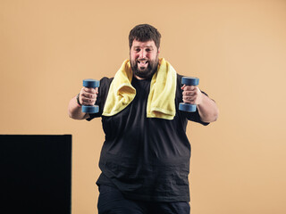 Portrait of a cheerful guy in a black T-shirt and overweight doing sports in an online class.
