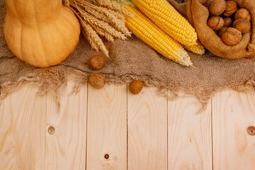  Autumn Thanksgiving table setting. Wooden table with pumpkins, corns, walnuts and autumn decor close up, 