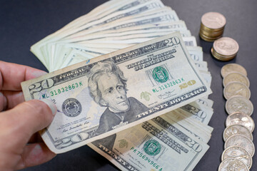 hand counting 20 dollar bills and coins