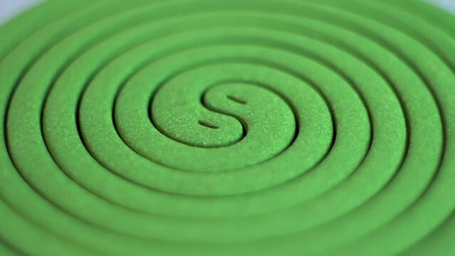 Mosquito repellent. Green spiral. Destruction of insects. Human protection. Comfort in the house. Rotation of an object. Close-up.