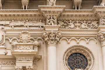 Detail of the richly decorated façade of the basilica of Santa Croce with statues, columns and rose window, Lecce city center, Salento, Puglia region, Southern Italy