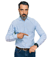 Middle aged man with beard wearing business shirt in hurry pointing to watch time, impatience,...