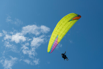 Paraglider pilot plot a turn overlooking the Atlantic coast with the sky in the background.