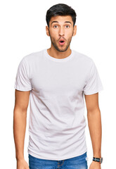 Young handsome man wearing casual white tshirt afraid and shocked with surprise expression, fear and excited face.
