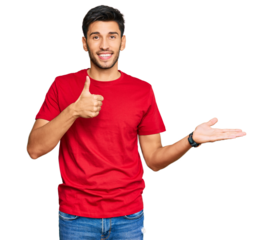 Young handsome man wearing casual red tshirt showing palm hand and doing ok gesture with thumbs up, smiling happy and cheerful