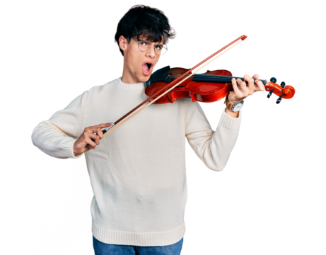 Handsome hipster young man playing violin in shock face, looking skeptical and sarcastic, surprised with open mouth