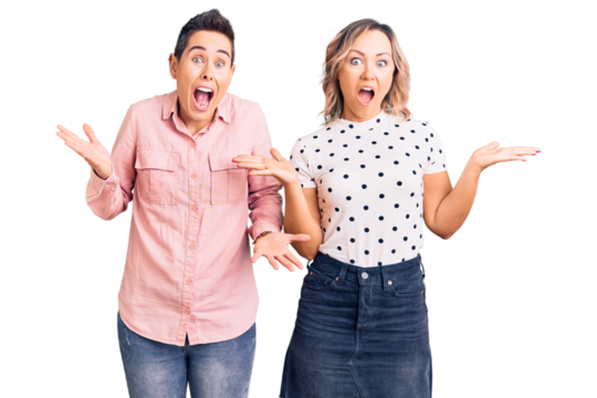 Couple of women wearing casual clothes celebrating victory with happy smile and winner expression with raised hands