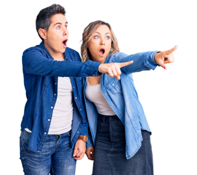 Couple of women wearing casual clothes pointing with finger surprised ahead, open mouth amazed expression, something on the front
