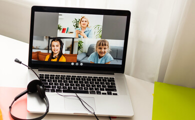 Closeup photo of little pretty pupil school lady talk skype notebook online lesson video call sit...