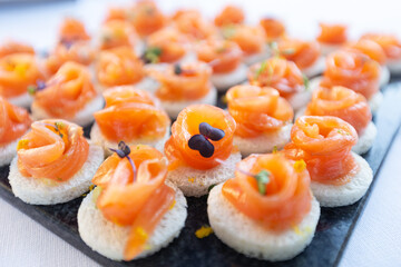 Salmon roll served at a wedding buffet. Gourmet aperitif at a party consisting of finger food.