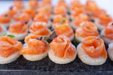 Salmon roll served at a wedding buffet. Gourmet aperitif at a party consisting of finger food.
