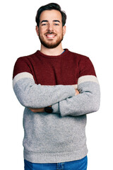 Young hispanic man wearing casual clothes happy face smiling with crossed arms looking at the camera. positive person.