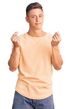 Young handsome man wearing casual clothes doing money gesture with hands, asking for salary payment, millionaire business