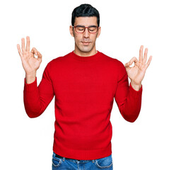 Handsome hispanic man wearing casual clothes and glasses relax and smiling with eyes closed doing meditation gesture with fingers. yoga concept.