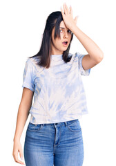 Fototapeta premium Young beautiful girl wearing casual t shirt surprised with hand on head for mistake, remember error. forgot, bad memory concept.