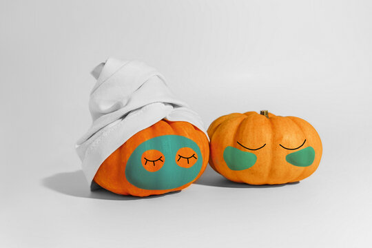 Pumpkin with facial mask and towel isolated on white background. Space for text mockup spa and Halloween concept