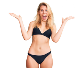 Young beautiful blonde woman wearing bikini celebrating crazy and amazed for success with arms raised and open eyes screaming excited. winner concept