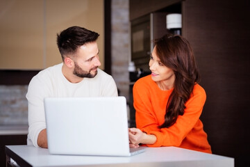 Smiling couple using laptop at home