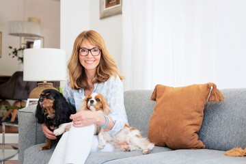 Happy woman with her cute puppies relaxing at home