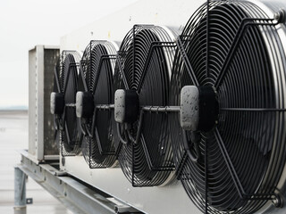 Industrial condenser fans on roof on rainy day used in air conditioning, refrigeration, heat pump...