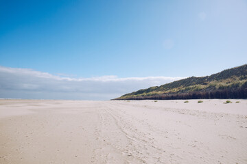 Fototapeta na wymiar Wide sandy beach on the North Sea. Beach by the sea in Holland, Germany or Denmark. dunes by the sea