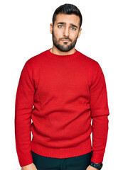 Fototapeta premium Young hispanic man wearing casual clothes looking sleepy and tired, exhausted for fatigue and hangover, lazy eyes in the morning.