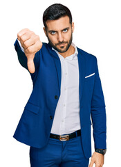 Young hispanic man wearing business jacket looking unhappy and angry showing rejection and negative...