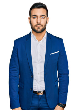 Young hispanic man wearing business jacket relaxed with serious expression on face. simple and natural looking at the camera.