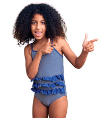 African american child with curly hair wearing swimwear pointing fingers to camera with happy and...