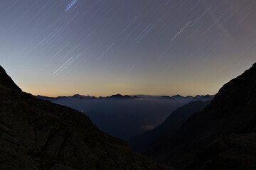 Star trails in the Alps above misty veil