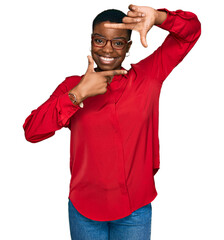 Young african american woman wearing casual clothes and glasses smiling making frame with hands and fingers with happy face. creativity and photography concept.