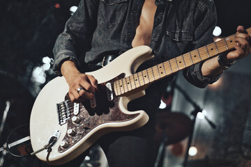Close-up of rock musician guitarist playing the electric guitar on stage