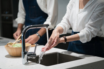 Family lifestyle Asian couples husband and wife cooking together. The couples are happily living together in the room, helping each other do the housework.
