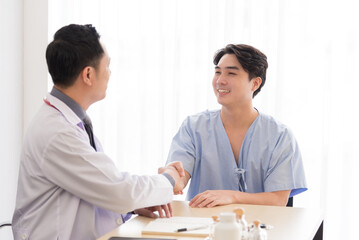 Asian doctor in professional work uniform discuss and cheer his patient with happiness and hopeful.