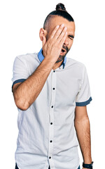 Fototapeta premium Hispanic man with ponytail wearing casual white shirt yawning tired covering half face, eye and mouth with hand. face hurts in pain.