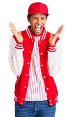 Young african amercian man wearing baseball uniform celebrating mad and crazy for success with arms raised and closed eyes screaming excited. winner concept