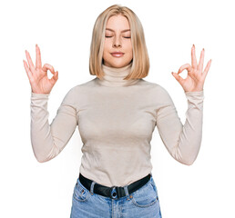Fototapeta na wymiar Young blonde woman wearing casual clothes relax and smiling with eyes closed doing meditation gesture with fingers. yoga concept.