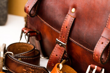 Brown leather bag and rolled up belt close-up.