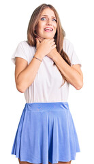 Young beautiful blonde woman wearing summer style shouting and suffocate because painful strangle....
