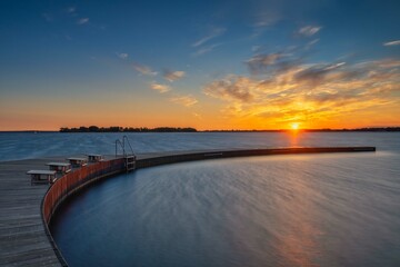 Obraz premium Swimming in the lake over sunrise