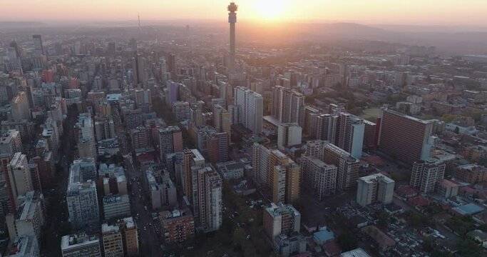 Aerial panning view of the magnificent Johannesburg City Centre at sunset surrounded by smog and pollution.