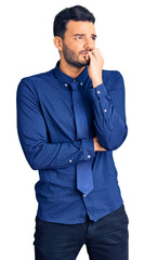 Fototapeta premium Young handsome hispanic man wearing business clothes looking stressed and nervous with hands on mouth biting nails. anxiety problem.