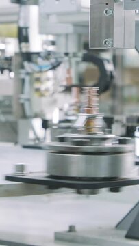 Vertical video of Advanced robotic machine manufacturing parts in an automated assembly line