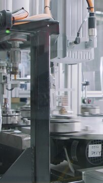 Vertical video of Advanced robotic machine manufacturing parts in an automated assembly line