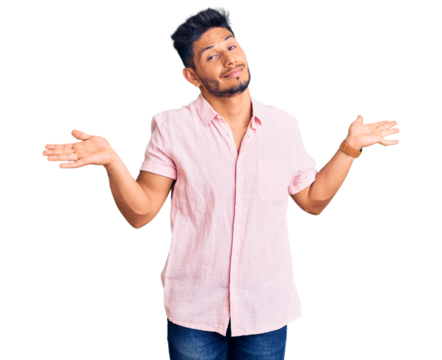 Handsome latin american young man wearing casual summer shirt clueless and confused expression with arms and hands raised. doubt concept.