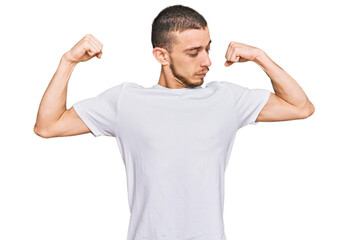 Naklejka premium Hispanic young man wearing casual white t shirt showing arms muscles smiling proud. fitness concept.